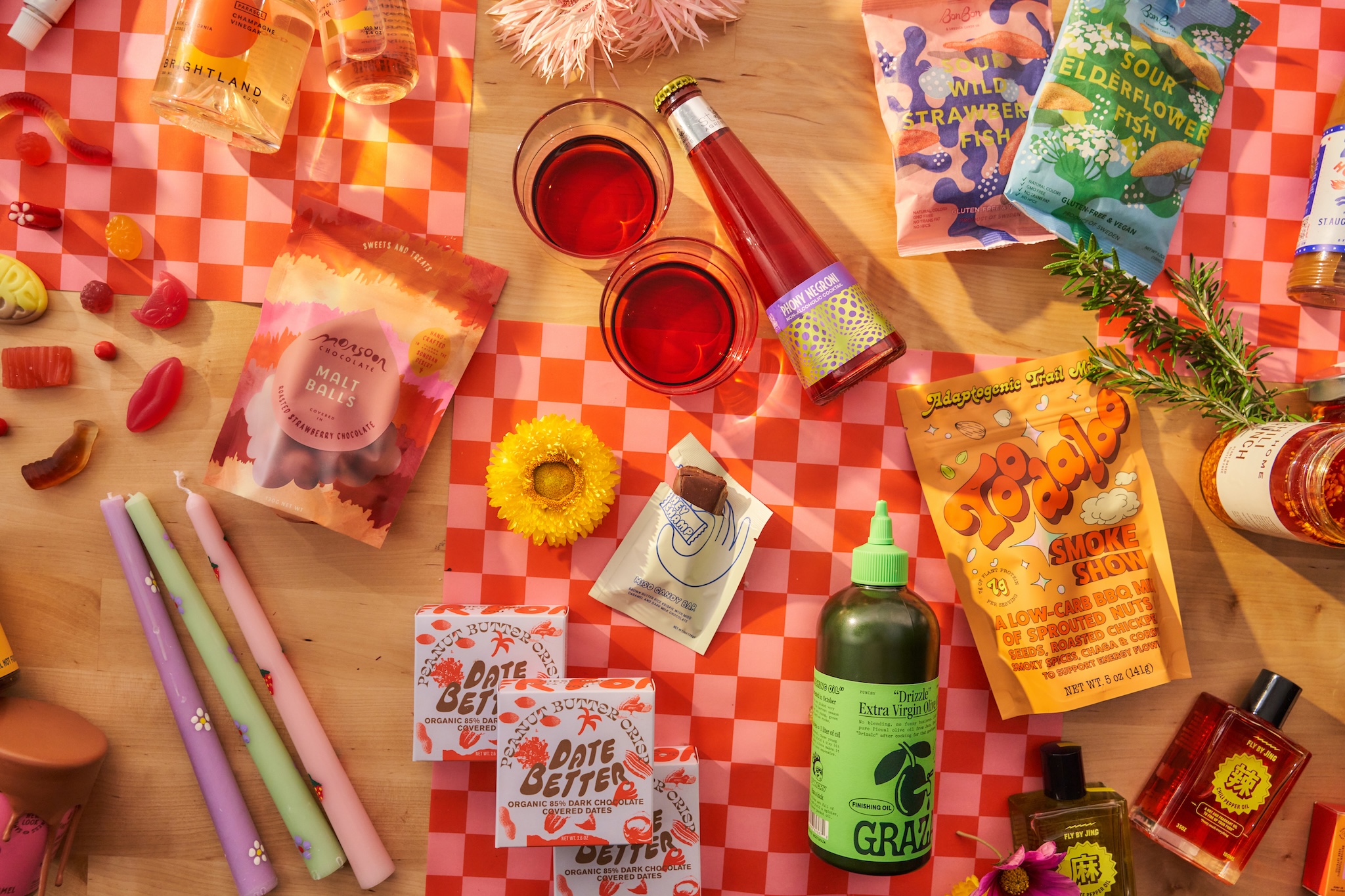a tabletop covered in brightly colored packaged food, drinks, and candles