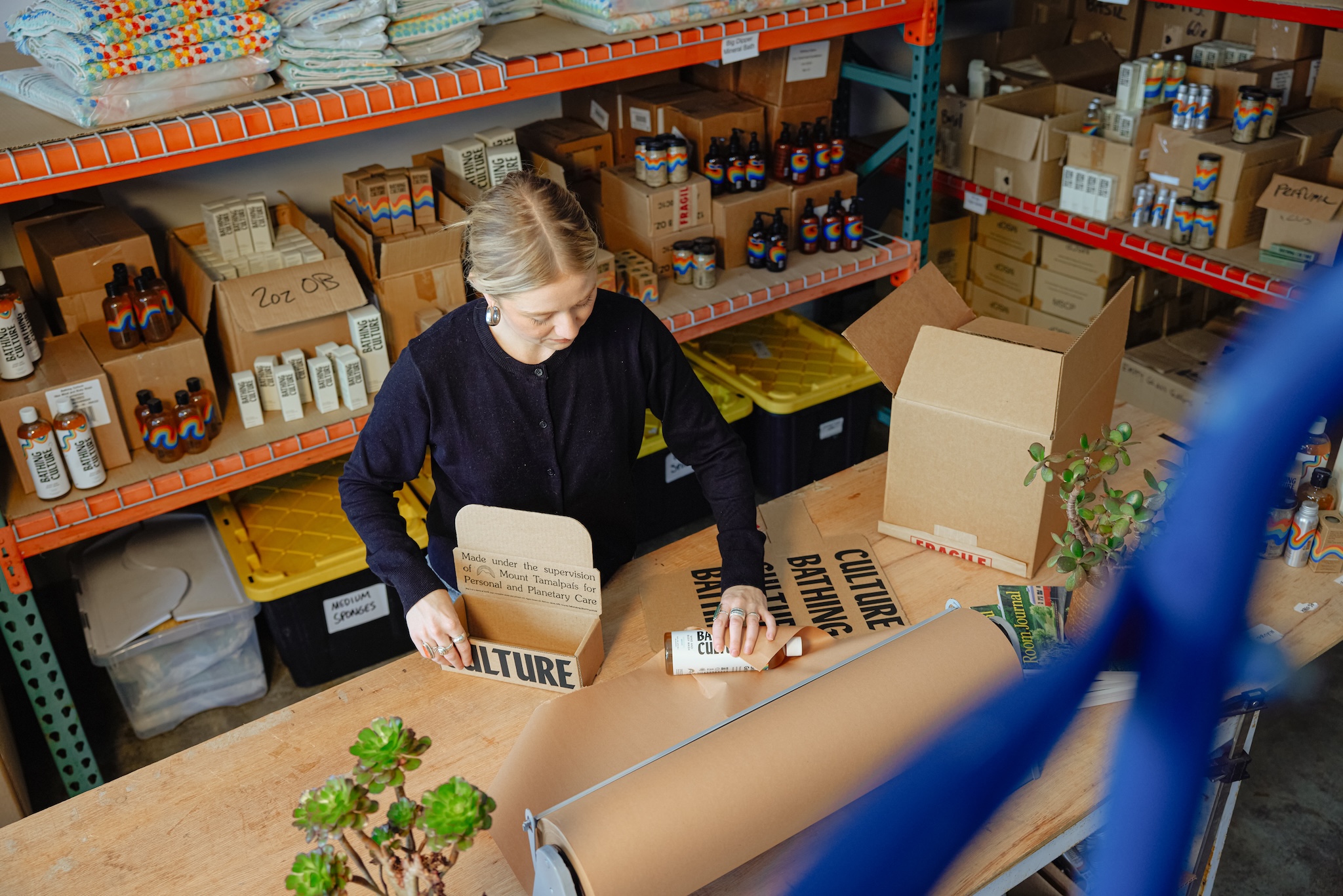 a worker packages items in brown cardboard boxes