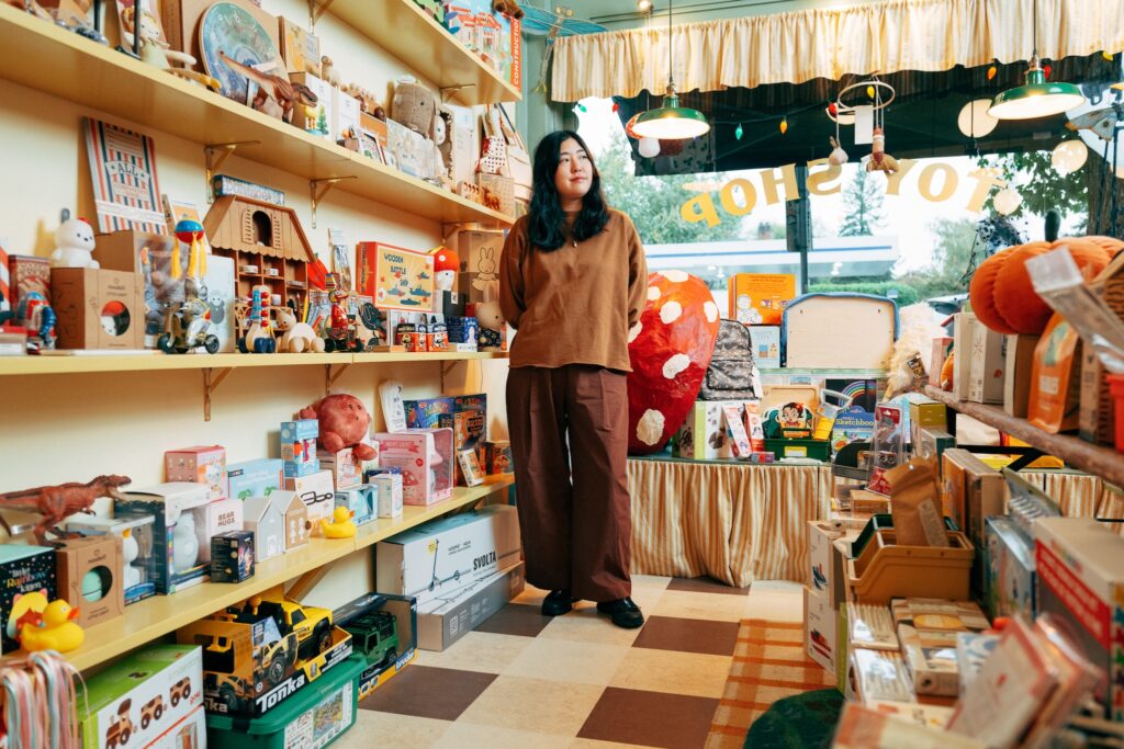 Woman in toy retail shop looking at items.