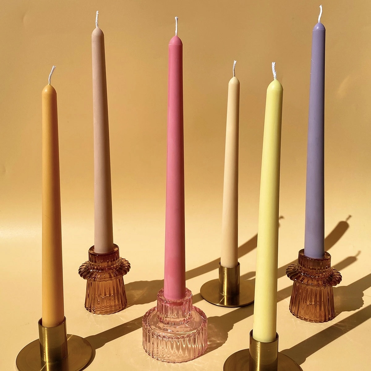 Colorful pillar candles in amber glass holders.
