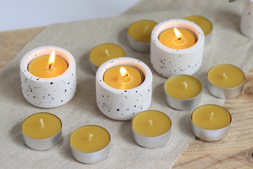 Yellow tealights in white speckled ceramic cups.