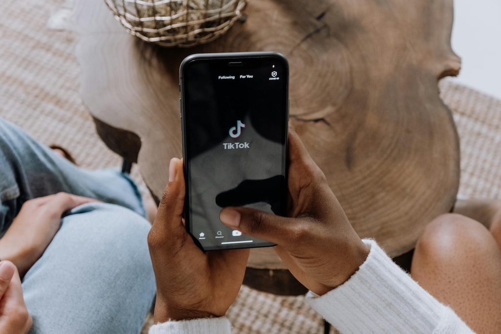 hands hold an iphone using the TikTok app