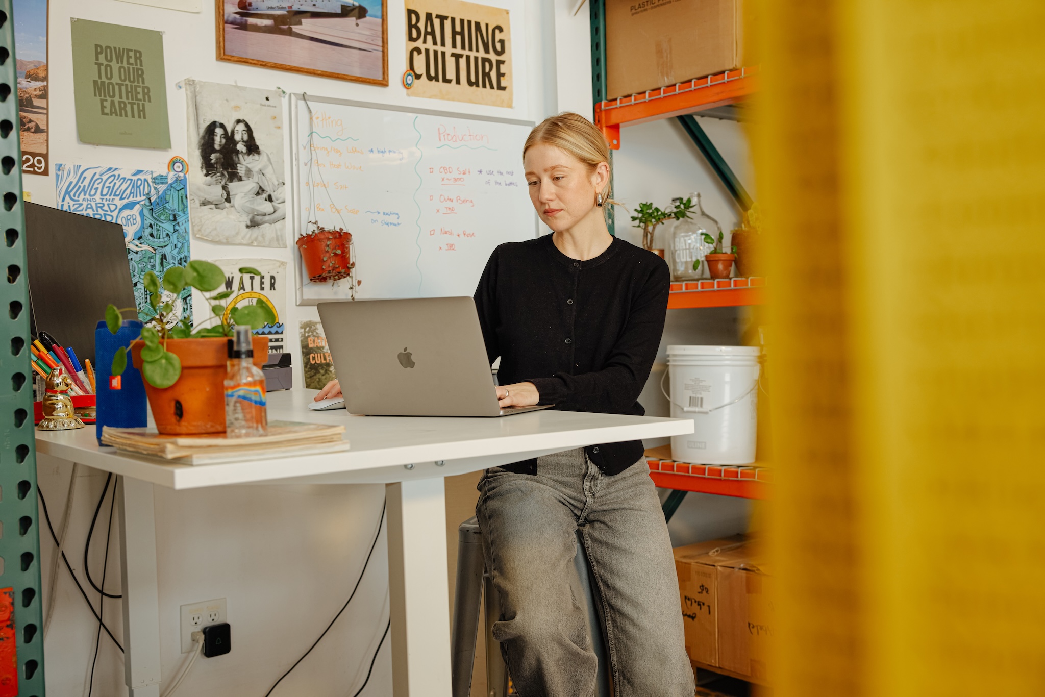 a woman works on a laptop at her desk