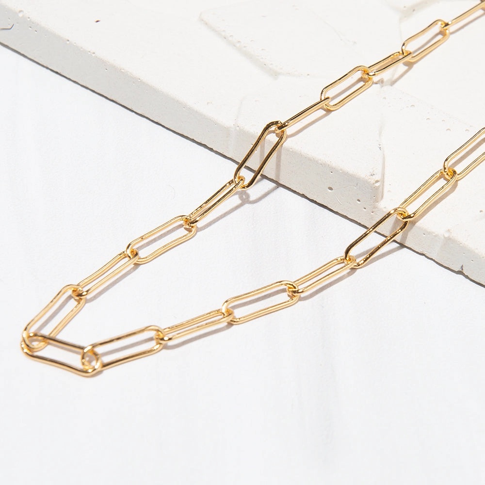Gold chain necklace on white background.
