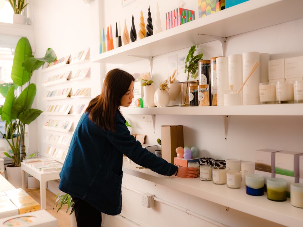 Commerçante alignant des bougies achetées chez un grossiste sur des étagères